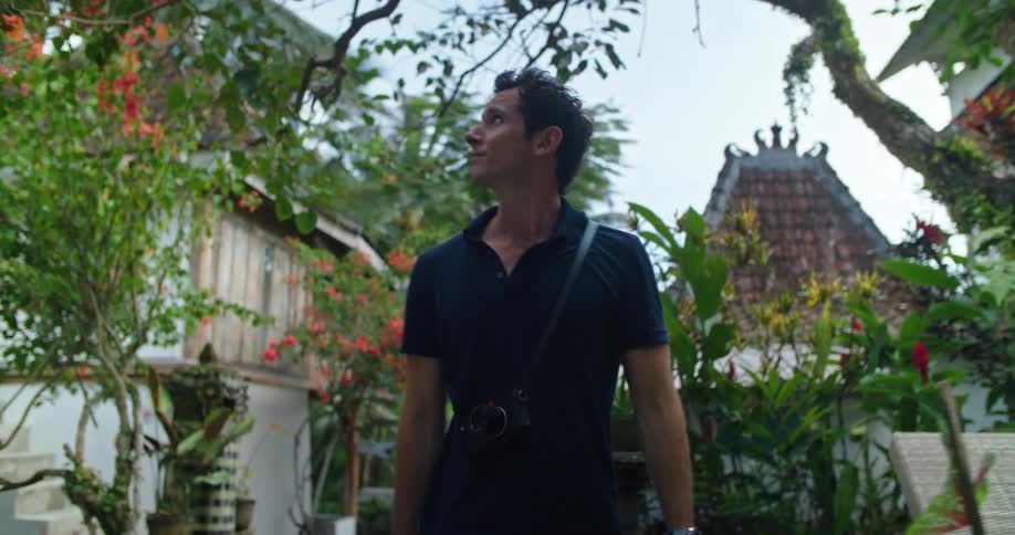 Photographer walks through garden in tropical exotic setting
