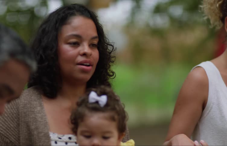 Family gathered around a table in the backyard praying before eating