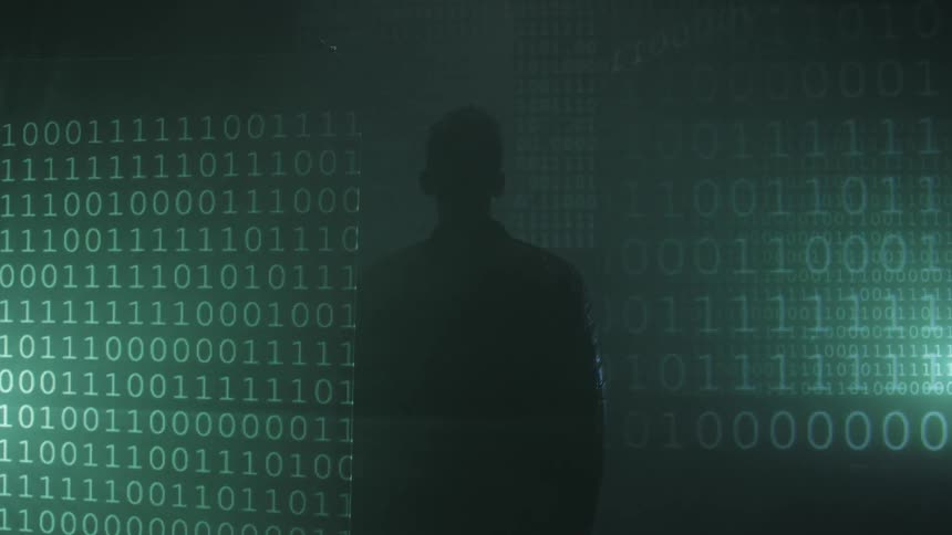 A man watches ones and zeros on a wall