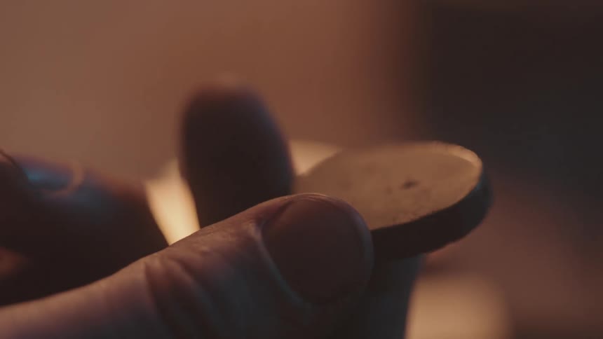 A man inspects a gray circle