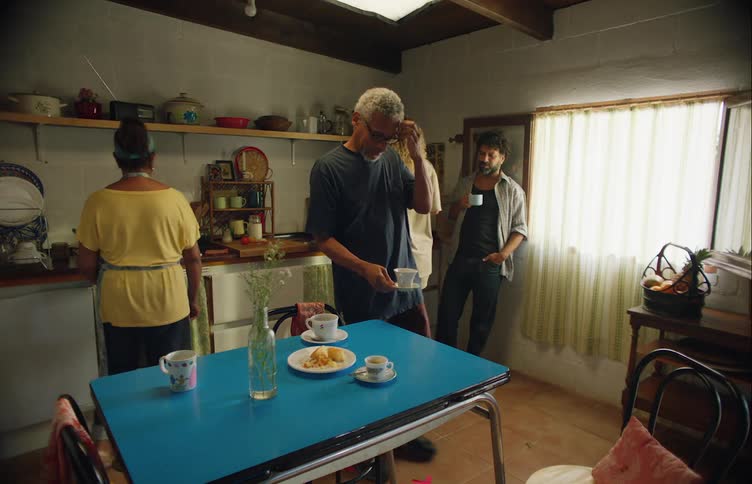 Family drinks coffee after finishing their meal in the kitchen