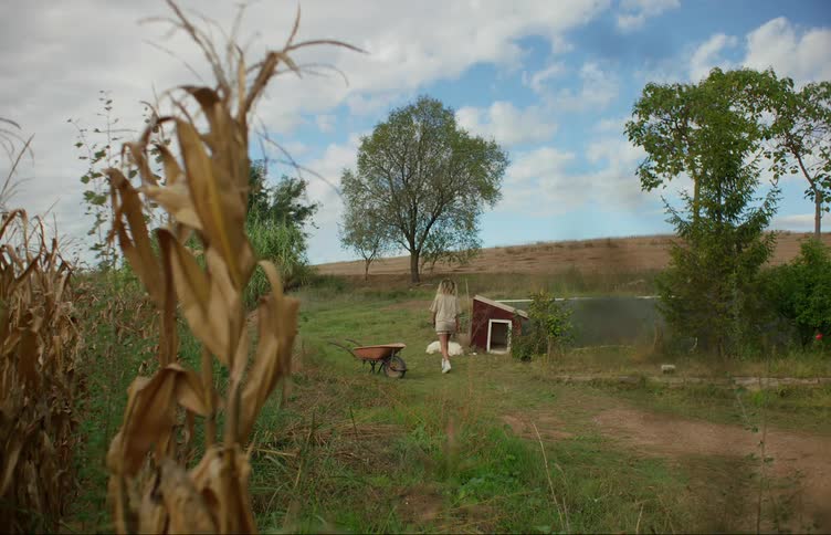 A woman walks over to a sleeping dog and crouches down to pet it