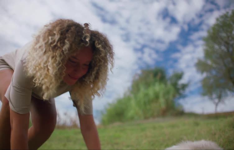 Woman cuddles dog lying on its side on ground then stands and leaves