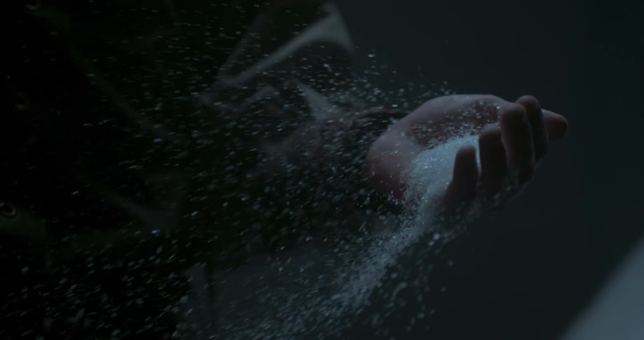 Crystals blow out of a person's hand