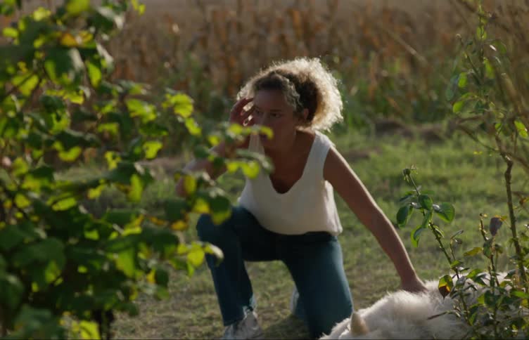 Woman is outdoors with her dog and a vehicle is pulling up outdoors