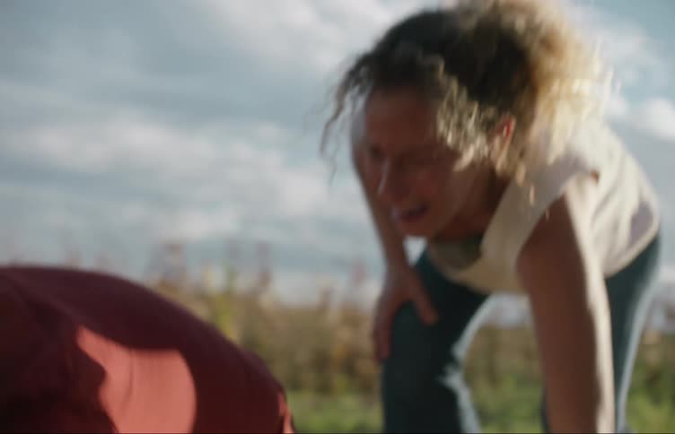 A man runs over to help a woman lift something then she runs off
