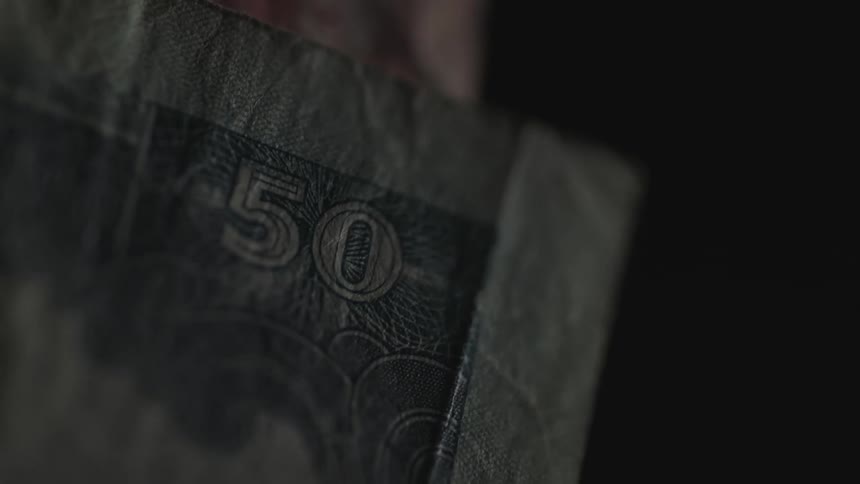 Light flashes on a fifty dollar bill