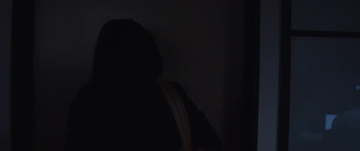 A woman opening her office door shutting off the light and shutting the door before she walks out