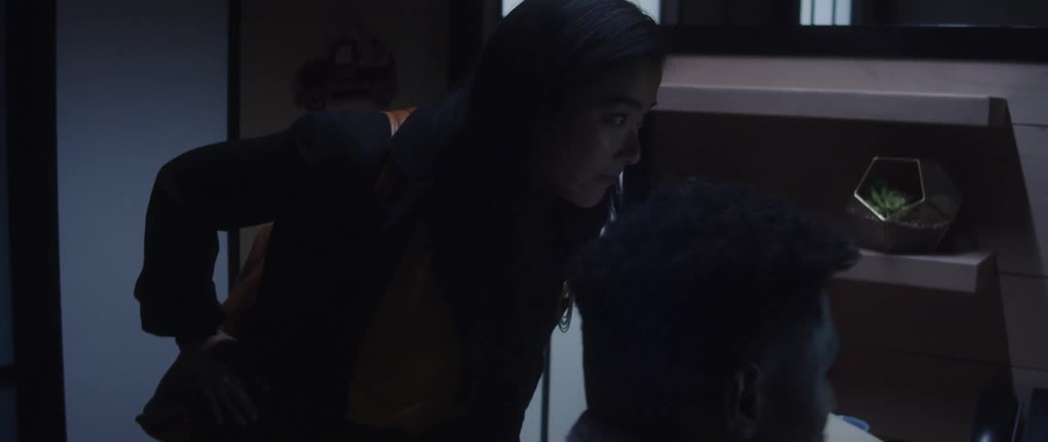A male and female coworker chatting in an office setting
