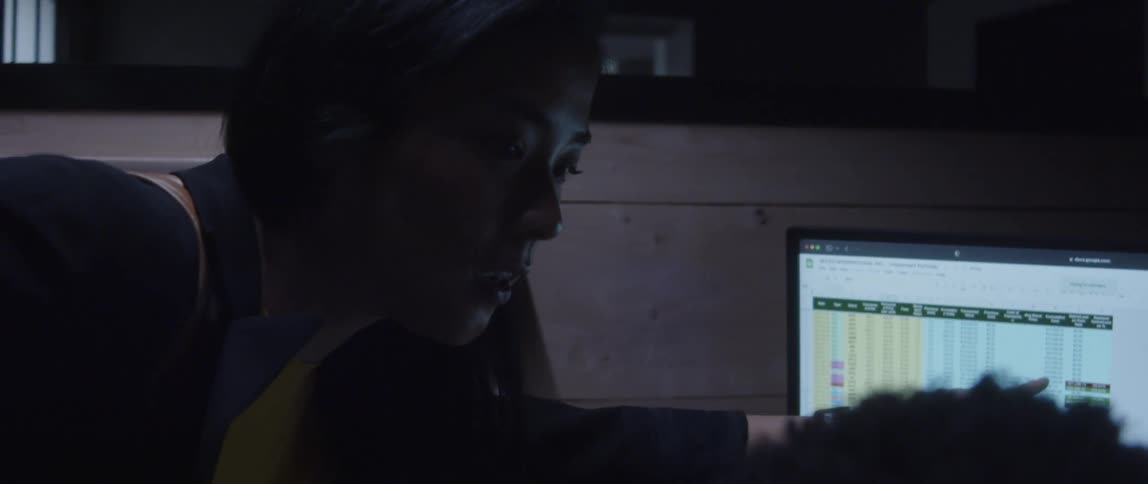 A woman explaining something to a coworker on a computer monitor
