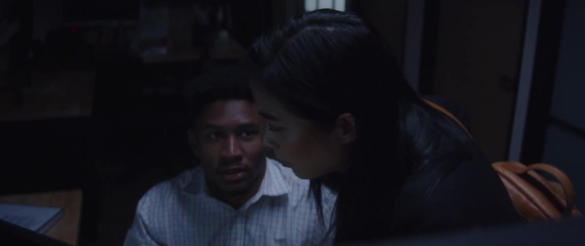 A black man is showing an important concept to an asian woman in an office setting