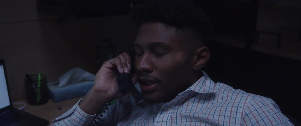 A man sitting at his desk talking on the phone