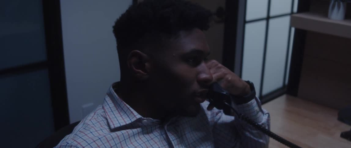 A man having an intense conversation with someone on a phone in an office