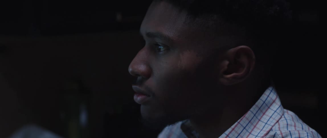 A close up of a mans face looking contemplatively and shaking his head slightly