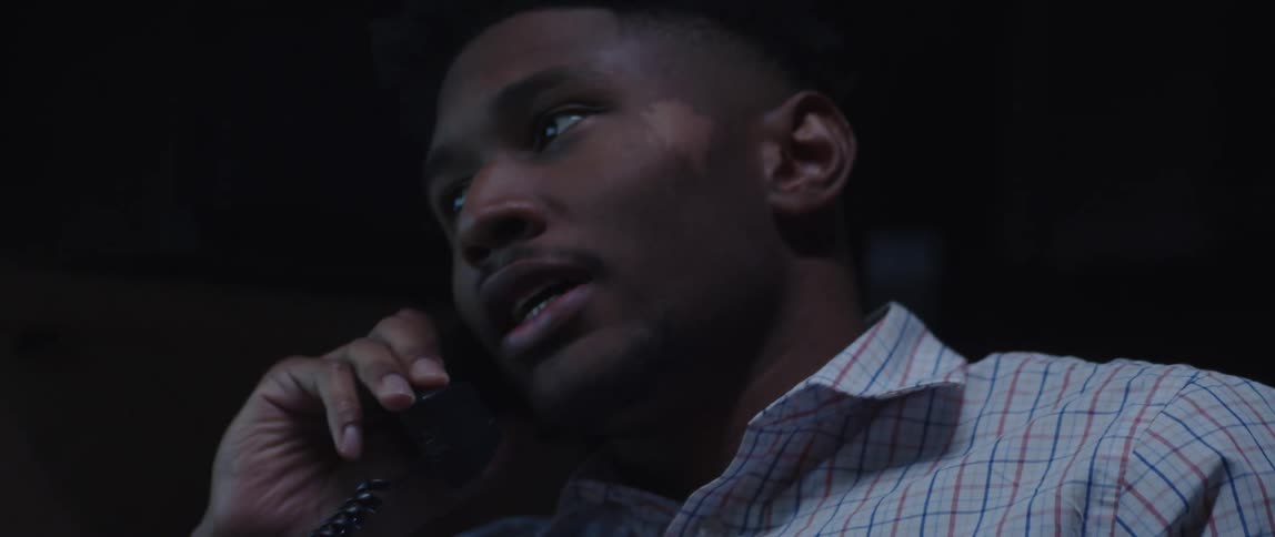 An up close of a mans face while he talks on a corded phone