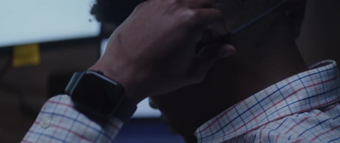 A man working at an office puts on bone-conducting headphones