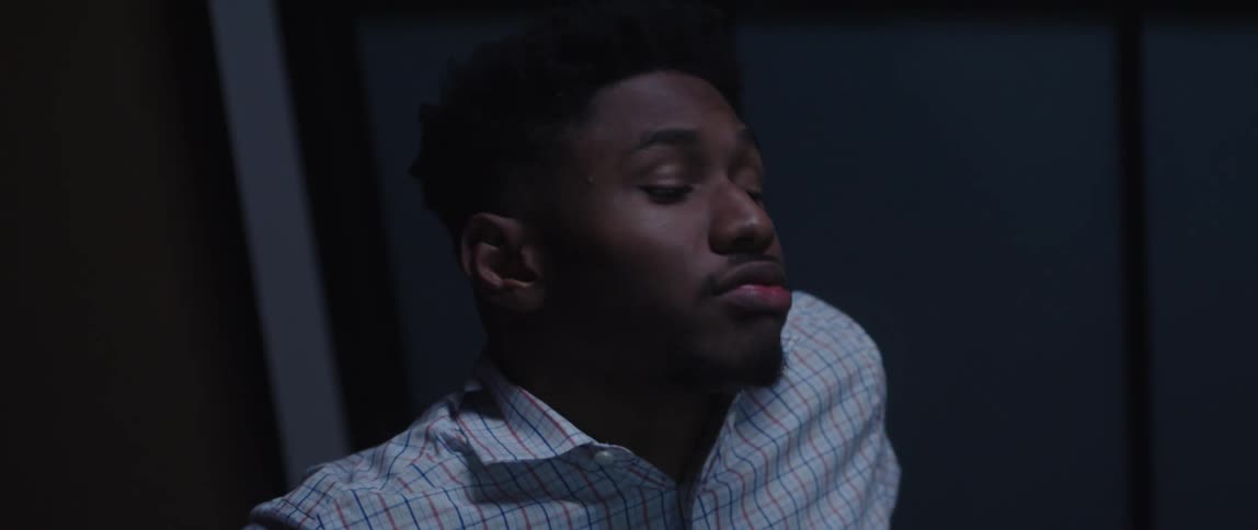 Man sighs and rubs his eyes while working long hours in a call center