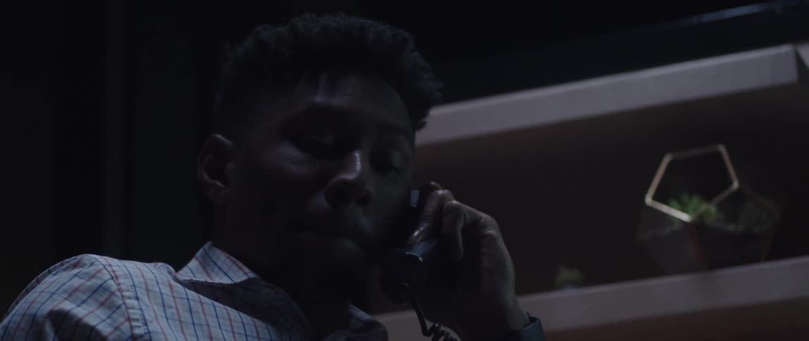 A man in an office talks on the phone
