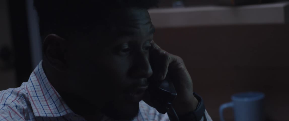 A man talking on a phone in an office