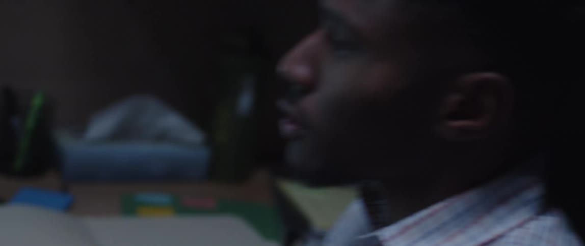 A man looking at papers and then at the computer screen