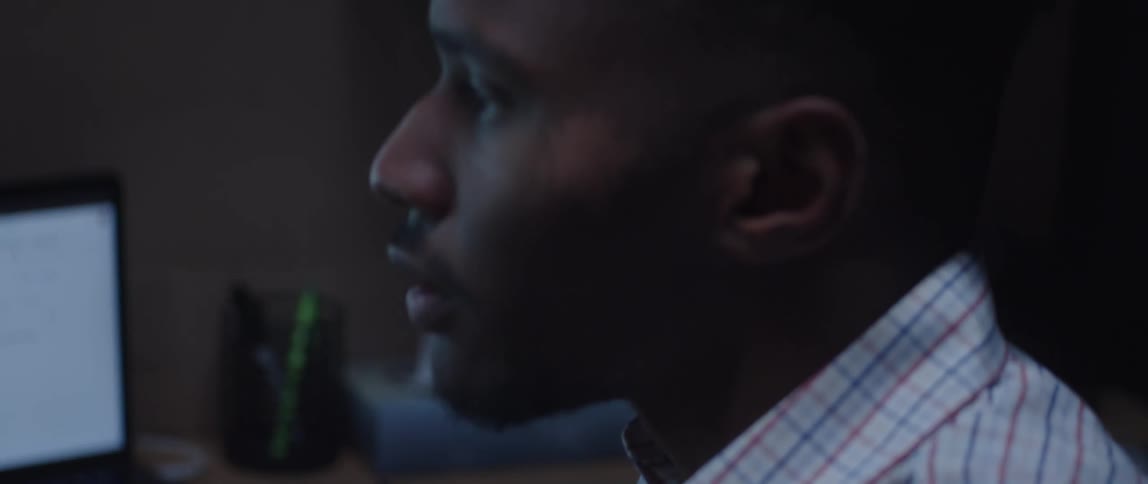 A male employee reviewing a past due account in an office cubicle