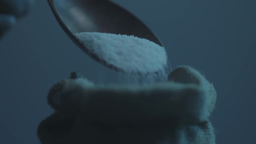A person spoons salt out of a bag