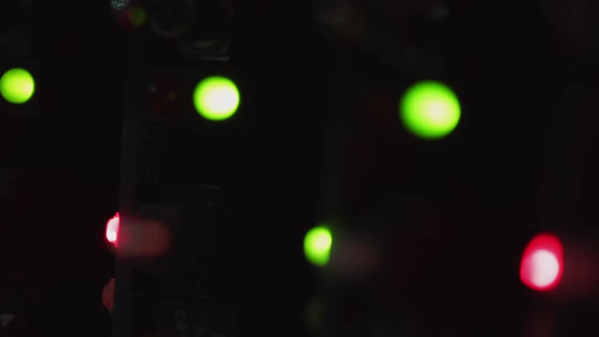 A close view of a control board with led lights in a dark environment with lights moving
