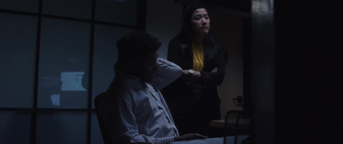 Businessman sitting in chair and businesswoman standing look at computer screen at the office
