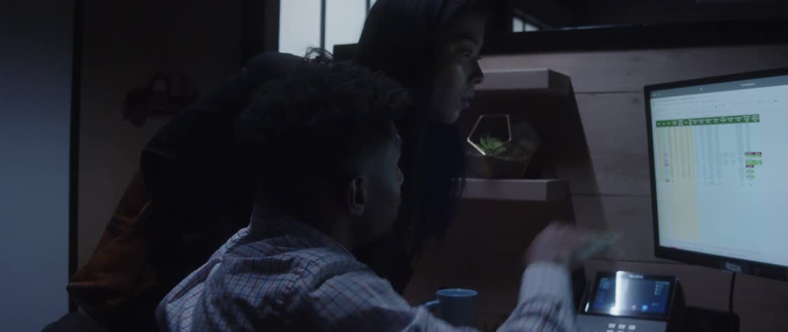 Businessman and businesswoman look at computer screen at the office