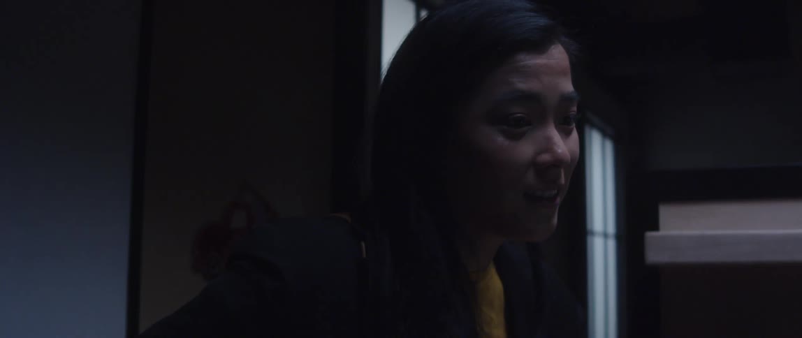 A woman speaks to a colleague at their cubicle