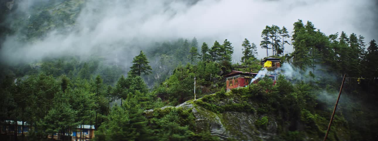Landscape of buildings on mountain slope while clouds floating