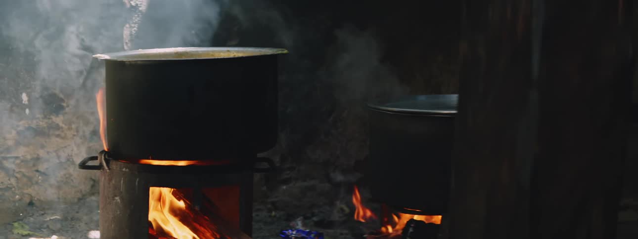 Cauldrons cooking food over fire