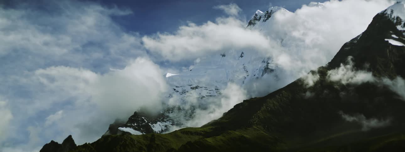 Landscape of snowy mountain ranges and white clouds floating