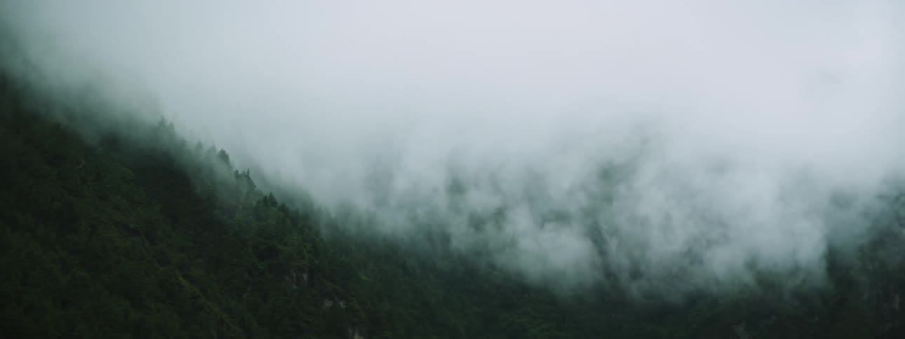 Clouds float over mountain slope