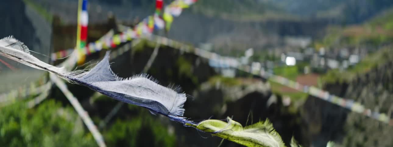 Flags hang from ropes suspended over hills near a neighborhood in a developing country