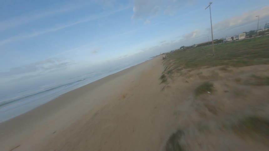 Sand covers wooden walkways on beach near town
