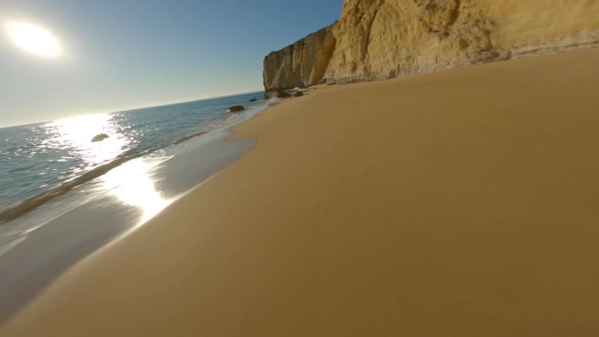 An aerial view of a coastal cliff with a sandy rocky beach