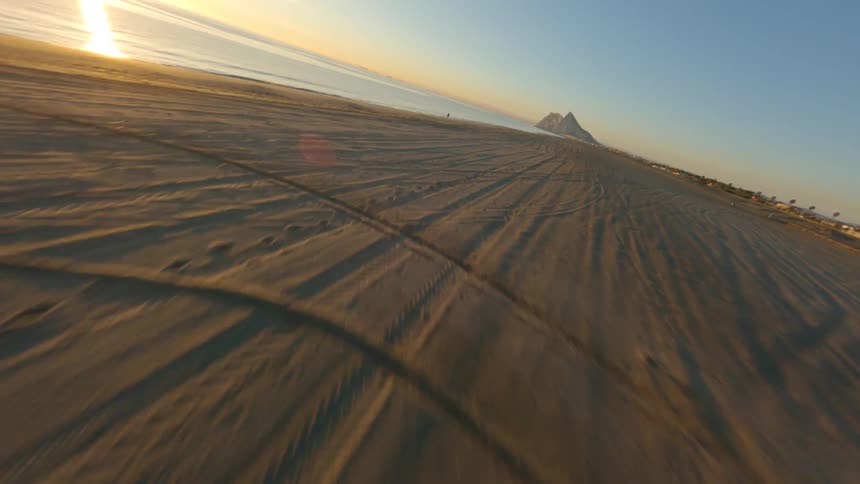 Aerial view of long beach near the ocean at sunset