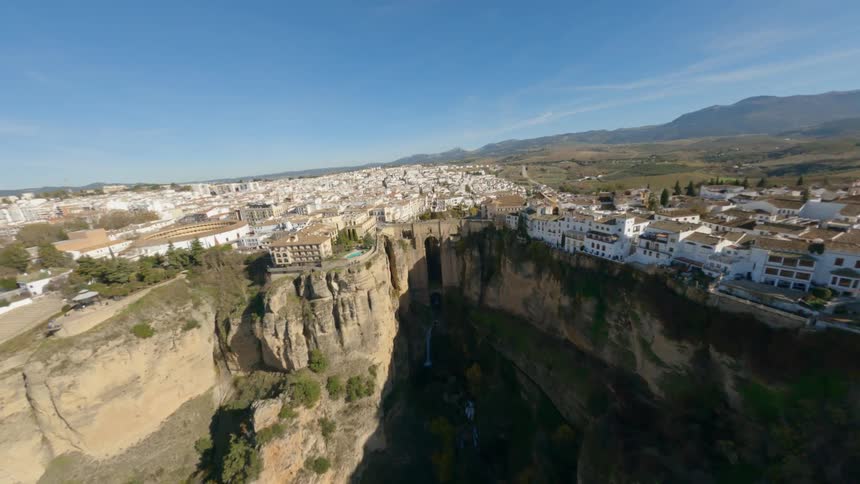 Buildings sit on cliffs in a town near a mountain range