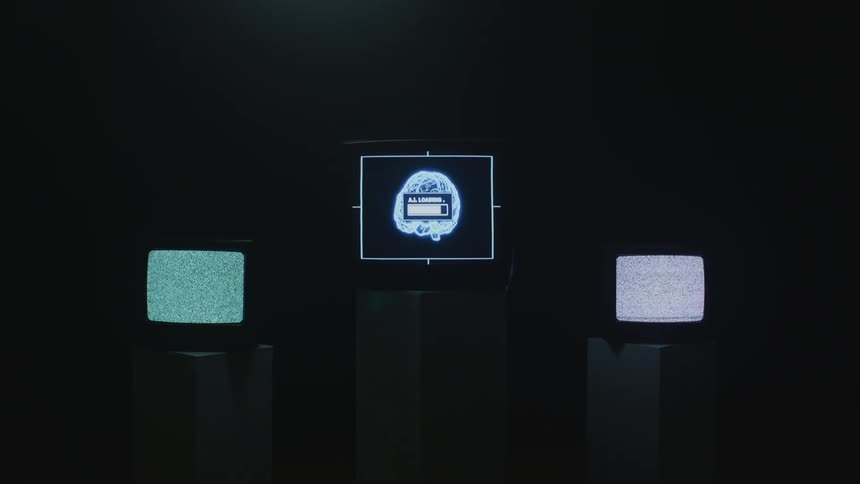 Three televisions on stands two have noise and the third in the middle has a brain loading up something