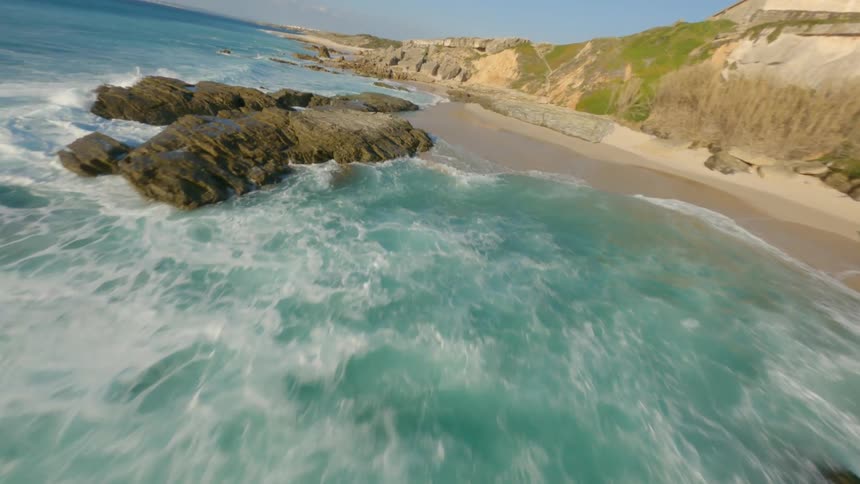 An aerial view of a rocky coastal beach on a summer day