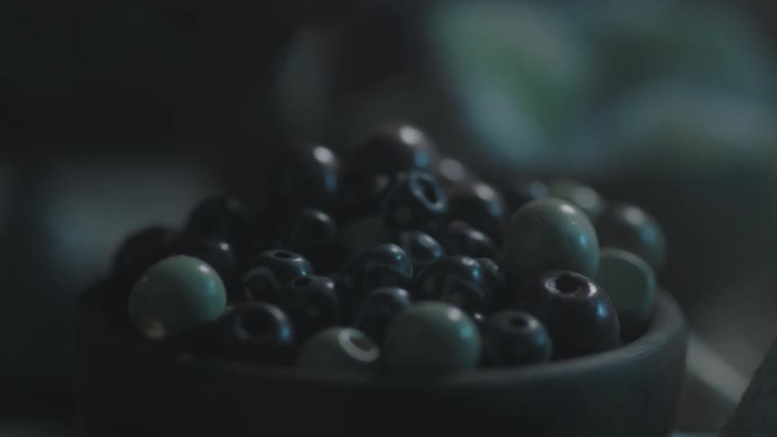 A person picks a bead from a bowl