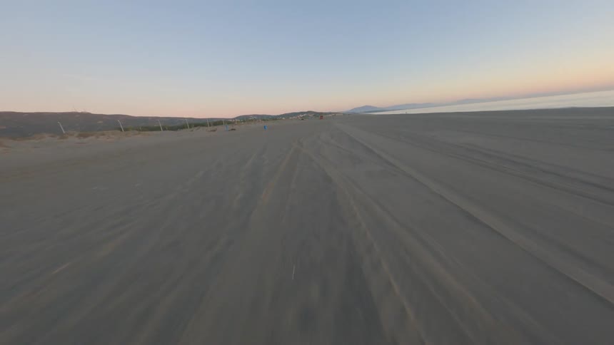 Aerial view of long beach near the ocean at dusk