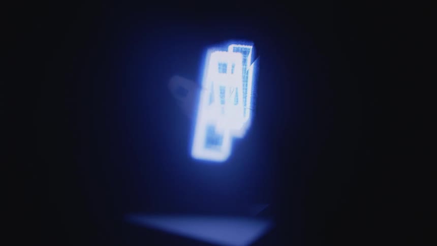 Close up of changing digital graphics spinning on a screen inside a dark room