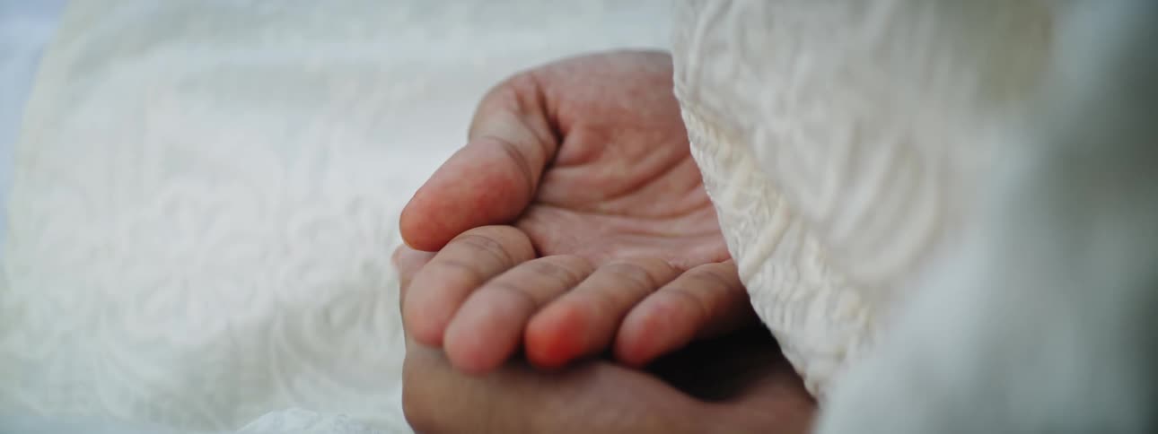 A persons hands resting on top of each other palm side up