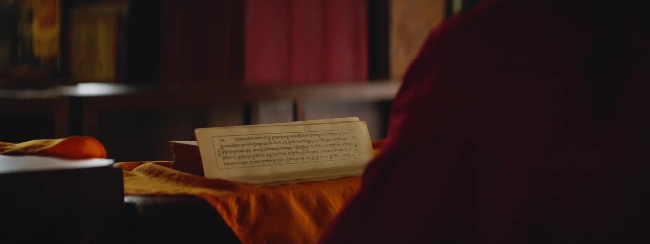 Buddhist Silhouette Engaged in Study: Table with Tibetan Scripture
