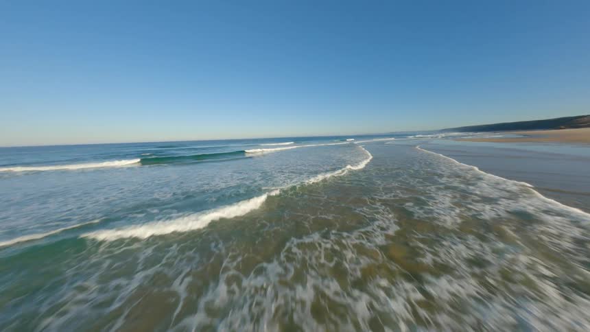 Aerial view of big long beach and ocean on a cloudless day