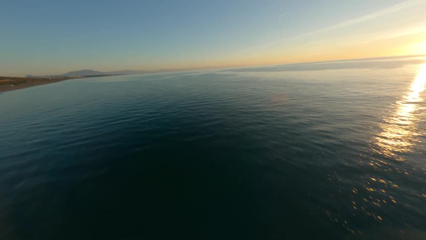 Aerial view of long beach near the ocean at sunset