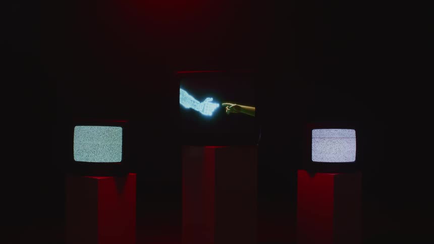 Static and images play on television screens in a dark room