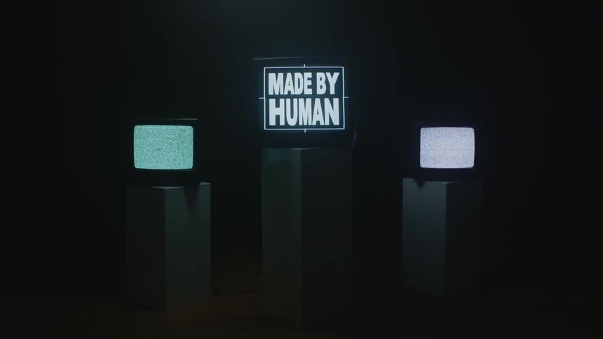 Static and text play on box style televisions placed on square columns in a dark room